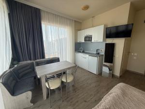 a room with a kitchen and a table and a couch at Apartment on Angisa, 78 in Batumi