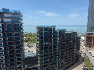 an aerial view of two tall buildings and the ocean at Apartment on Angisa, 78 in Batumi