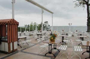 a patio with tables and chairs and the ocean at Pension Radke in Heringsdorf +67 photos