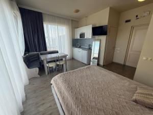 a bedroom with a bed and a kitchen and a table at Apartment on Angisa, 78 in Batumi