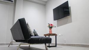 a black chair in a room with a vase of flowers at Bellazio Aparthotel in Iquitos