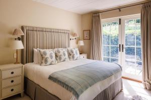 a bedroom with a bed and a large window at The Three Daggers in Edington
