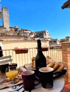 a table with a bottle of wine and a plate of food at Affittacamere Chiti Melania in San Gimignano