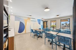 a dining room with tables and chairs and a kitchen at Ocean Breeze in San Juan