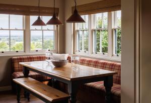 a table and a couch in a room with windows at The Three Daggers in Edington