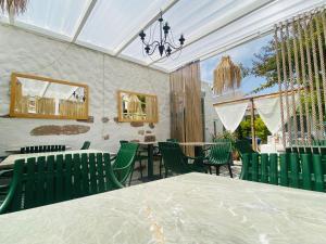 a dining room with green chairs and a table at BadeHan Guest House in Çeşme