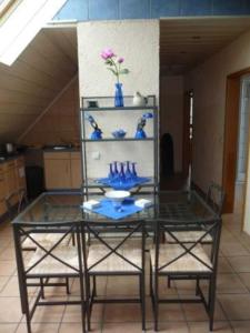 a glass table with two chairs and blue vases on it at 4_Zimmer_Ferienwohnung in Wathlingen