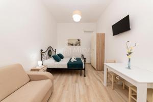a living room with a bed and a couch at LORY'S HOUSE in Porto Cesareo