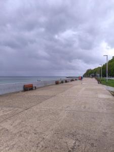 a beach with benches and the ocean on a cloudy day at Hostel Tet6 in Gdynia