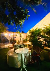 a patio with a table and chairs in a yard at BadeHan Guest House in Çeşme