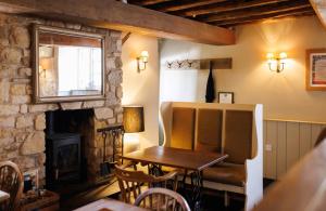 a dining room with a table and a fireplace at The Three Daggers in Edington