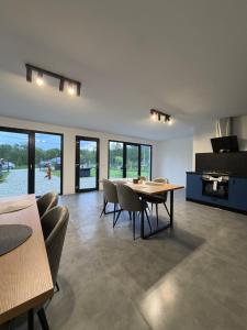 a dining room with a table and chairs and windows at The DREAM A-frame Cabin in Arpaşu de Sus +32 photos