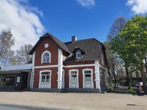 a large brick house with white windows on a street at Familie Hensen - FeWo mit überdachter Terrasse im Ortskern von Tarp in Tarp