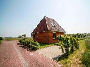 a small building on the side of a brick road at Ferienhaus Rieke in Friedrichskoog-Spitze