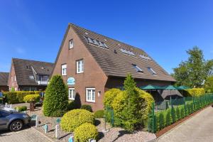 a brick house with a fence in front of it at Haus Nordseesterne in Bensersiel