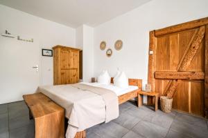 ein Schlafzimmer mit einem Bett und einer Holztür in der Unterkunft Weizenkammer in Rechlin