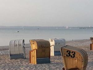 a group of beach chairs and tables on the beach at Strandhaus Buchtmitte in Haffkrug +67 photos
