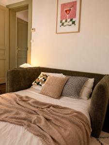a bed with a blanket on it in a room at L'Escapade Mussipontaine in Pont-à-Mousson