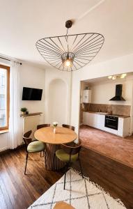 a dining room with a table and chairs and a chandelier at L'Escapade Mussipontaine in Pont-à-Mousson