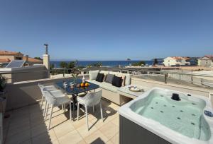 a hot tub on a balcony with a table and chairs at Marilena Mare Seaside & Jacuzzi House 50meters from sea in Ialysos