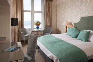 a bedroom with a bed and a table and a window at The Headland Hotel and Spa in Newquay +45 photos