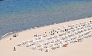 a group of chairs on a beach next to the water at Appartementhaus Sellin in Ostseebad Sellin +140 photos