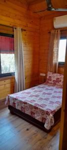 a bedroom with a bed in a log cabin at Wonderville Villa in Cuncolim