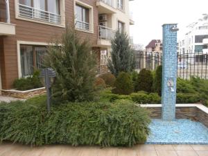 a garden in front of a building with a parking meter at Apartment Horisont 1 in Sozopol