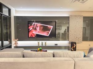 a living room with a couch and a flat screen tv at Morning Sea 1 เปิดใหม่!! พัทยาเหนือใกล้ทะเล ใกล้ Terminal21 in North Pattaya