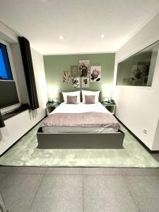 a bedroom with a large bed and two windows at LH Apartments Aulendorf in Aulendorf