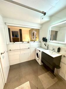 a bathroom with a sink and a washing machine at LH Apartments Aulendorf in Aulendorf