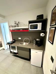 a small kitchen with a sink and a microwave at LH Apartments Aulendorf in Aulendorf +14 photos