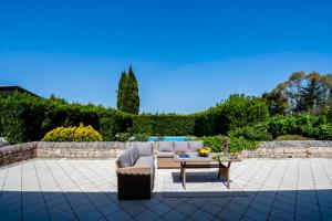 a patio with a couch and a coffee table at Villa Balata di Modica con piscina privata in Ragusa