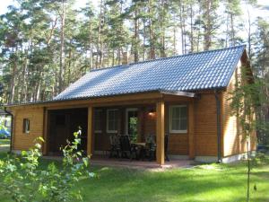 a small cabin with a porch and a table at Dependance Ferienhäuser am Kastavensee in Lychen