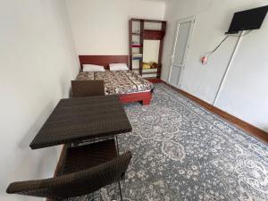 a bedroom with a bed and a table and chairs at Hotel Parus in Balykchy