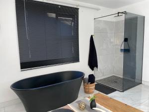 a bathroom with a black tub and a shower at Team Sek Guest Studio in Mahikeng +11 photos