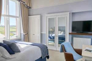 a hotel room with a bed and a tv at The Headland Hotel and Spa in Newquay