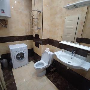 a bathroom with a toilet and a sink and a washing machine at Квартира Марсельська in Kryzhanivka