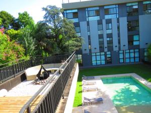 a swimming pool in front of a building at Araucarias Apartamentos in Moreno