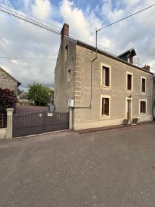 a large white brick building with a fence at Comme en 40 in La Lande-sur-Drôme