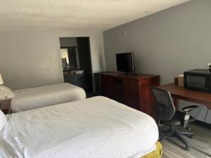 a hotel room with two beds and a desk with a computer at Home Town Inn in Flint