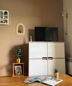 a white cabinet with a television on top of it at Appartement en bord de lac in Malbuisson