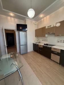 a kitchen with brown cabinets and a refrigerator at Квартира Марсельська in Kryzhanivka