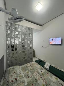 a bedroom with a bed and a tv on the wall at Studio - Serraruna in Araruna