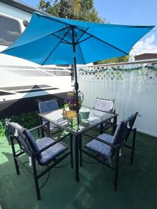 a table with two chairs and a blue umbrella at Paradise RV in Tampa
