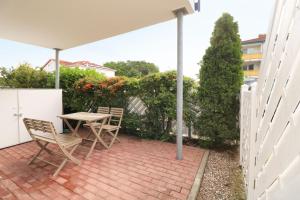 a patio with a table and chairs on a brick patio at Ferienwohnung Maigloeckchen 05 str in Karlshagen