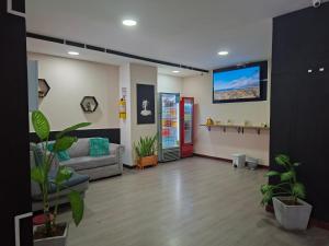 a living room with a couch and a flat screen tv at Hotel Gallery By 70 in Medellín