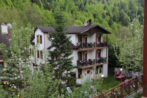 a large white house with a balcony at ABANT DORT MEVSİM KONAĞI HOSTEL in Dereceören