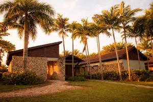 a building with palm trees in front of it at Villa Alda Bávaro in Punta Cana