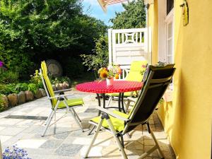 a patio with a red table and four chairs at Rosenhof Ferienwohnungen in Mölln-Medow
